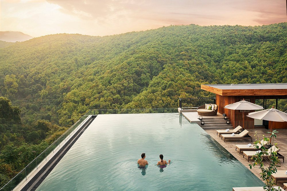 The Hyatt Regency Dehradun infinity pool overlooking densely forested Himalayan foothills